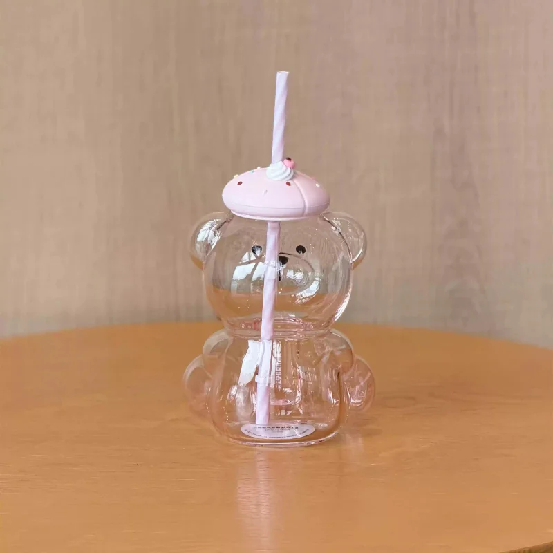 Cute 660ml clear bear-shaped glass tumbler with a pink silicone lid, reusable straw, and playful design, ideal for iced coffee, bubble tea, smoothies, and cold drinks.