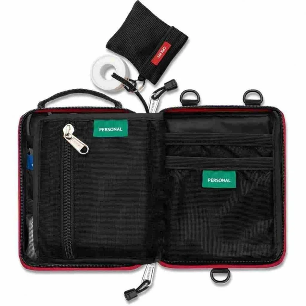 Compact personal first aid kit in a red zippered pouch with organized emergency medical supplies for hiking, camping, travel, outdoor adventures, and everyday preparedness.