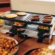 Swissmar Verso 8 person raclette grill with reversible cast iron grill and griddle top, individual raclette pans and adjustable heat control for indoor or outdoor dining.