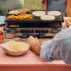 Swissmar Verso 8 person raclette grill with reversible cast iron grill and griddle top, individual raclette pans and adjustable heat control for indoor or outdoor dining.