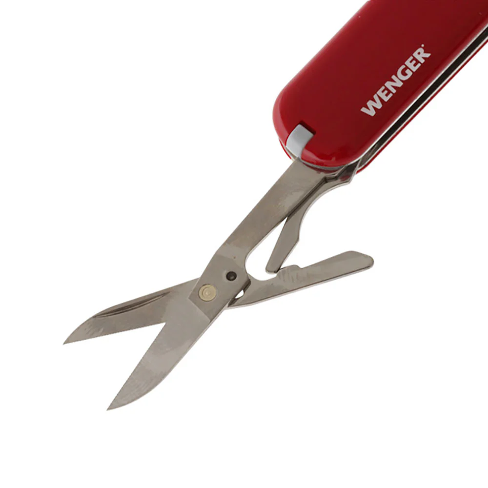 Victorinox Wenger multi-tool pocket knife featuring a compact 6.5cm red handle and a versatile Swiss-made design. This lightweight pocket tool includes a stainless steel blade, precision scissors, nail file, screwdriver tip, key ring, and additional every