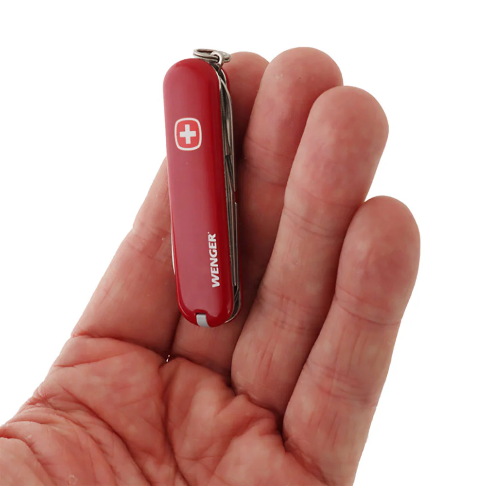 Victorinox Wenger multi-tool pocket knife featuring a compact 6.5cm red handle and a versatile Swiss-made design. This lightweight pocket tool includes a stainless steel blade, precision scissors, nail file, screwdriver tip, key ring, and additional every