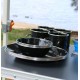 Wildtrak premium 12-piece enamel dinner set with plates, bowls and mugs featuring speckled black finish designed for camping, caravanning, picnics and outdoor dining adventures