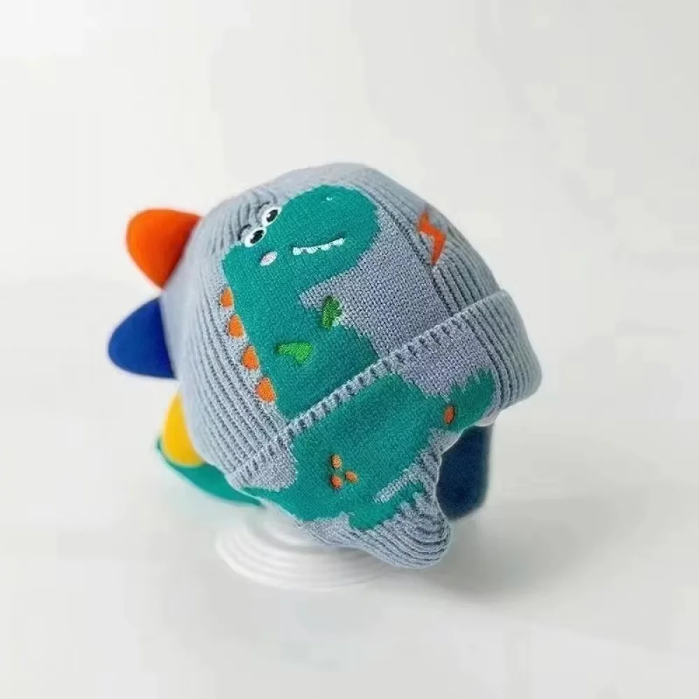 3D Dinosaur Kids Winter Beanie with Ear Protection Adorable knitted kids winter beanie featuring a playful 3D dinosaur design with colorful spikes, ear flaps, and a soft ribbed cuff. Made from warm, comfortable knit fabric, this toddler and children's hat provides excellent cold-weather protection for the