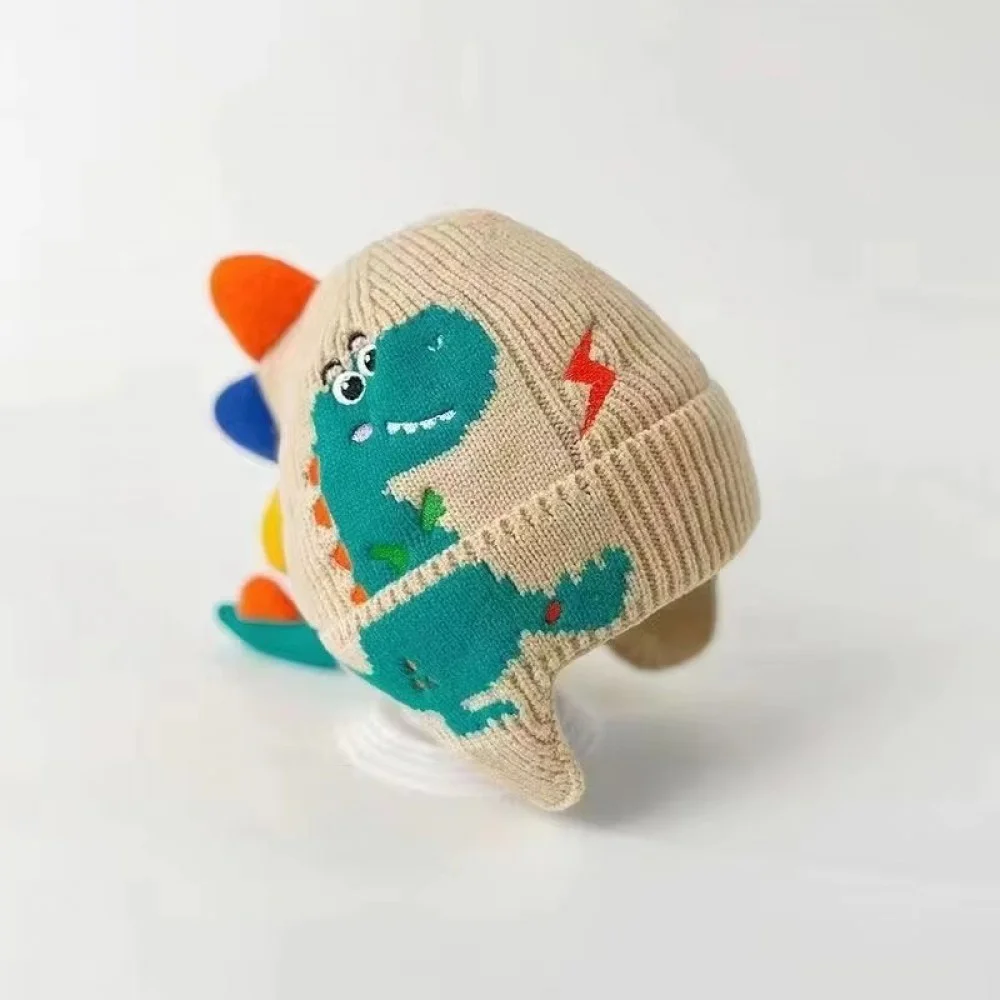 3D Dinosaur Kids Winter Beanie with Ear Protection Adorable knitted kids winter beanie featuring a playful 3D dinosaur design with colorful spikes, ear flaps, and a soft ribbed cuff. Made from warm, comfortable knit fabric, this toddler and children's hat provides excellent cold-weather protection for the
