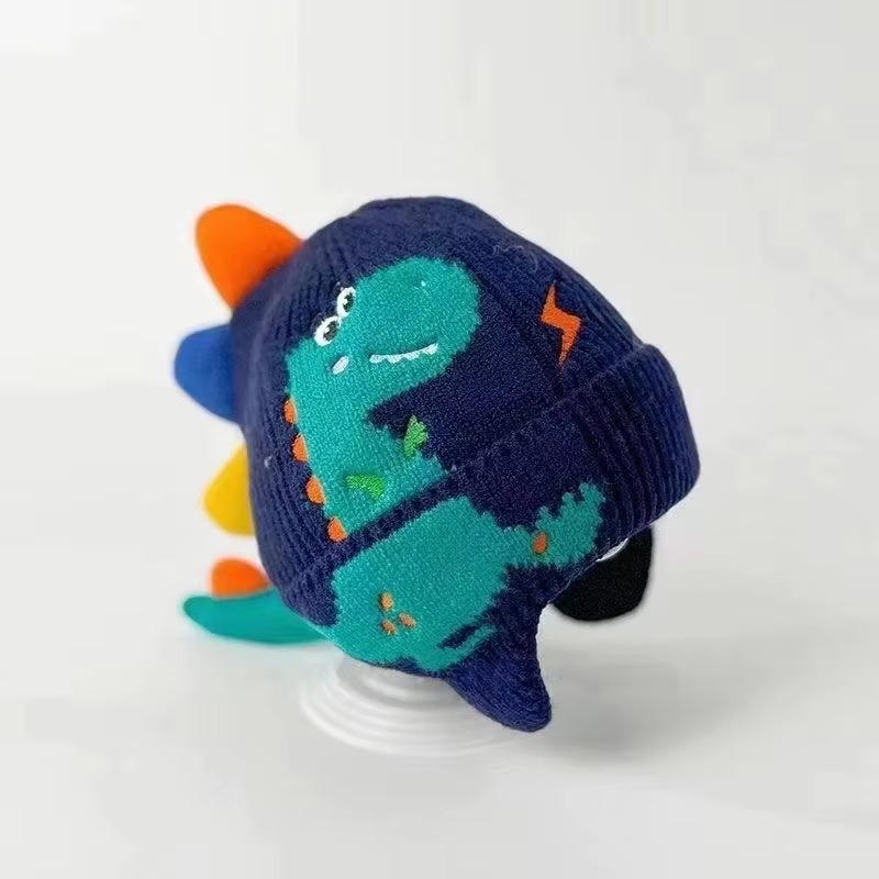 Adorable knitted kids winter beanie featuring a playful 3D dinosaur design with colorful spikes, ear flaps, and a soft ribbed cuff. Made from warm, comfortable knit fabric, this toddler and children's hat provides excellent cold-weather protection for the