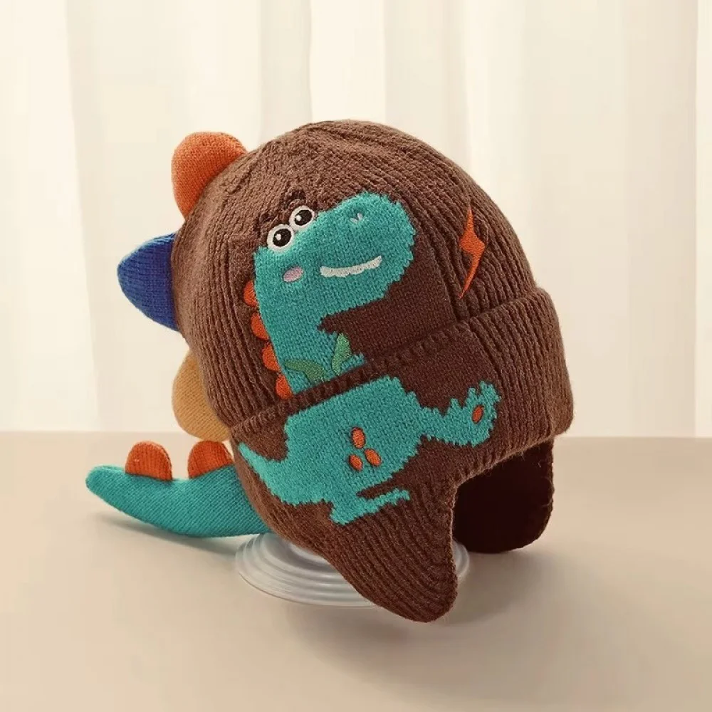 3D Dinosaur Kids Winter Beanie with Ear Protection Adorable knitted kids winter beanie featuring a playful 3D dinosaur design with colorful spikes, ear flaps, and a soft ribbed cuff. Made from warm, comfortable knit fabric, this toddler and children's hat provides excellent cold-weather protection for the