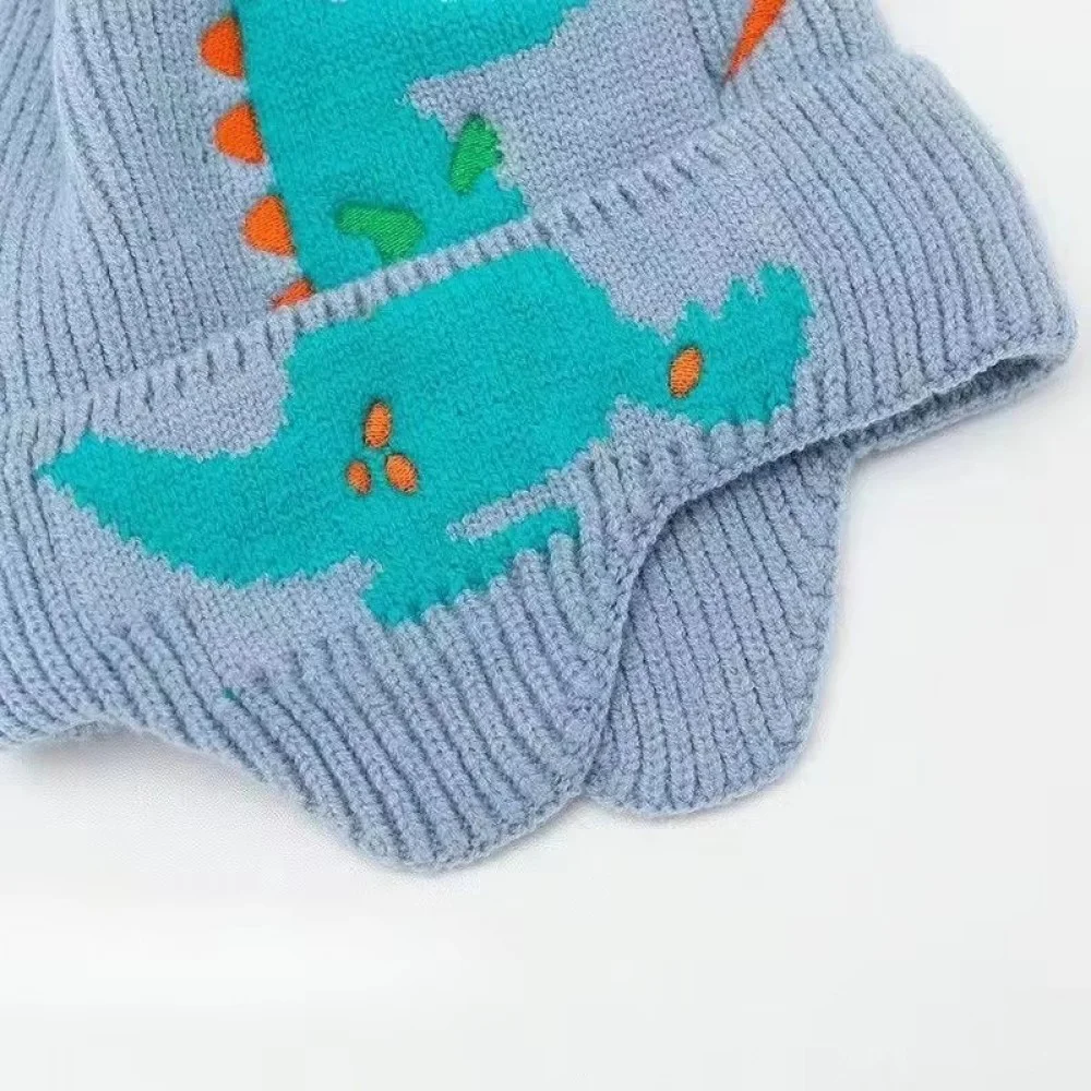 3D Dinosaur Kids Winter Beanie with Ear Protection Adorable knitted kids winter beanie featuring a playful 3D dinosaur design with colorful spikes, ear flaps, and a soft ribbed cuff. Made from warm, comfortable knit fabric, this toddler and children's hat provides excellent cold-weather protection for the