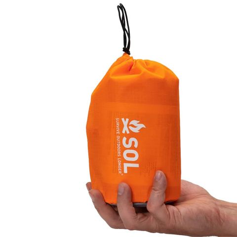 SOL Emergency Tent Set Up as A-Frame Shelter in Forest Orange reflective SOL Emergency Tent rigged as a two-person survival shelter in the woods