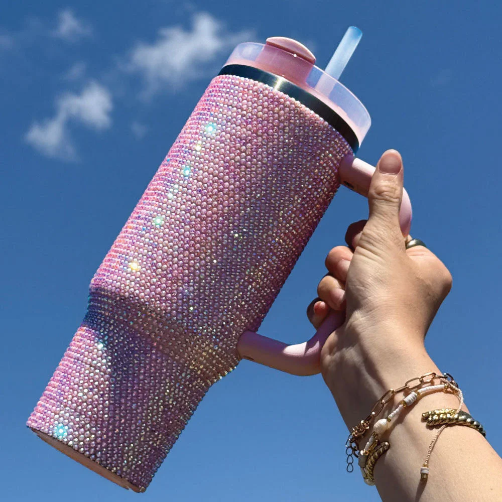 Luxe Pink insulated stainless steel tumbler with a large handle, reusable straw, and two interchangeable lids for convenient hot and cold beverage use.