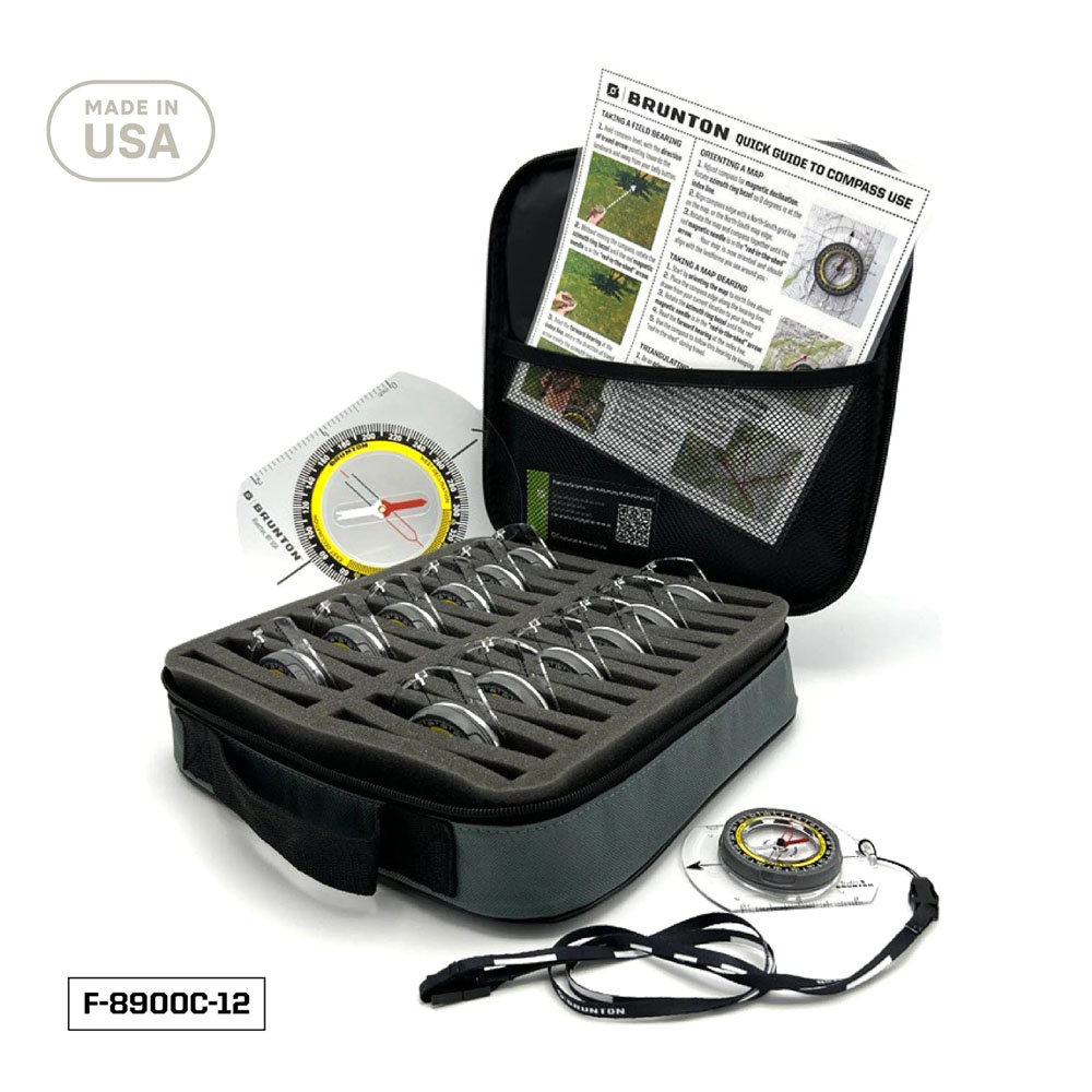 Top-down view of Brunton Compass Instructor Kit including 12 compasses neatly arranged in a foam-padded carrying case, instructional materials, and lanyards.