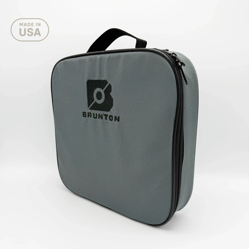 Top-down view of Brunton Compass Instructor Kit including 12 compasses neatly arranged in a foam-padded carrying case, instructional materials, and lanyards.