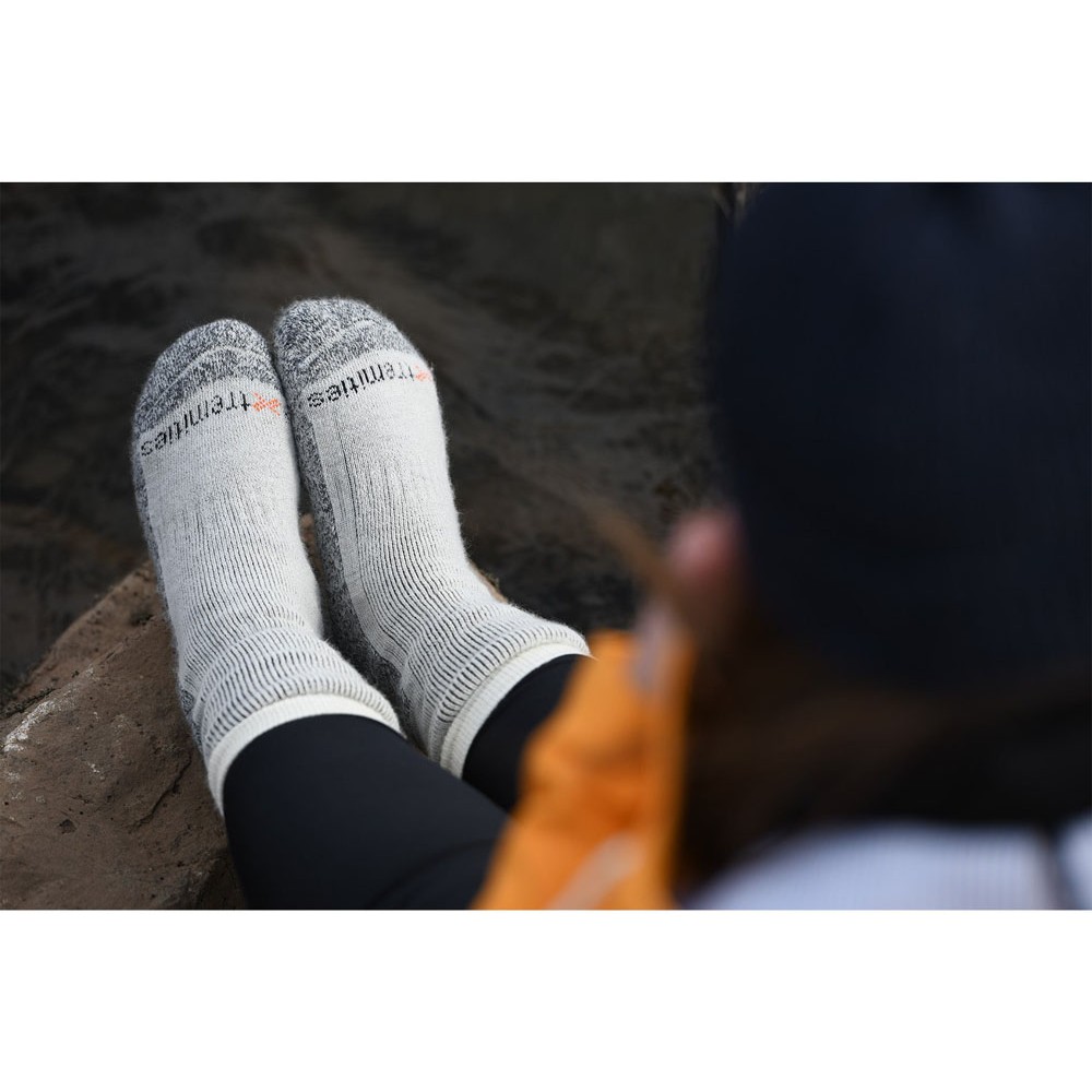 Warm Outdoor Hiking Socks for Trekking Camping and Winter Adventures Person wearing Extremities Mountain Toester thermal hiking socks while relaxing outdoors near water during camping and trekking trip