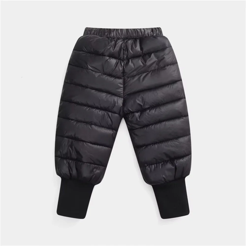 Lightweight insulated kids winter down pants designed with a quilted puffer construction, elastic waistband, and ribbed ankle cuffs for enhanced warmth and comfort. These windproof snow trousers help retain body heat while protecting children from cold we