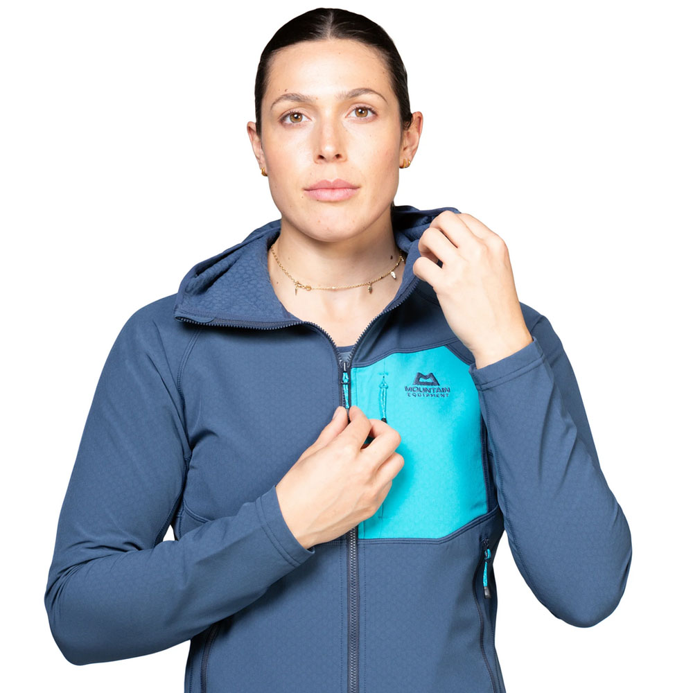 Mountain Equipment Arrow Jacket – Zip Adjustment Woman adjusting the front zip on the Mountain Equipment Arrow hooded jacket in blue and aqua colorway