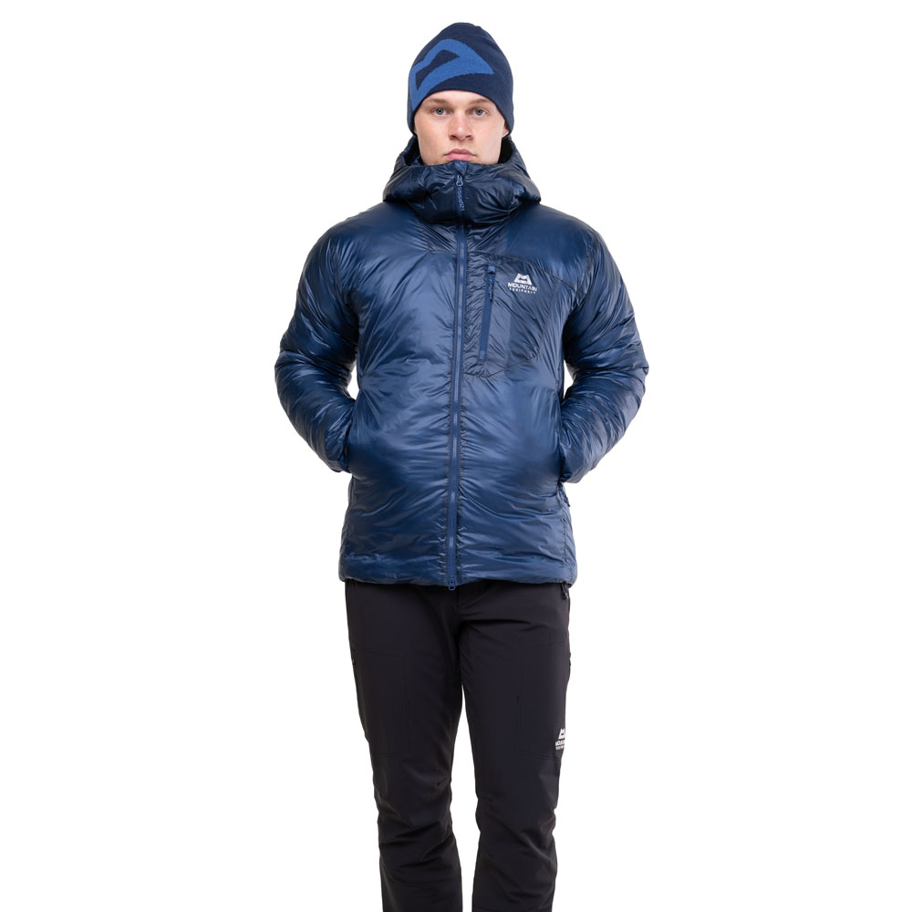 Man wearing Mountain Equipment Oreus jacket in, shown front-facing with hands in pockets