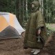 Camper resting inside insulated hammock underquilt during outdoor camping in forest environment for warmth and comfort