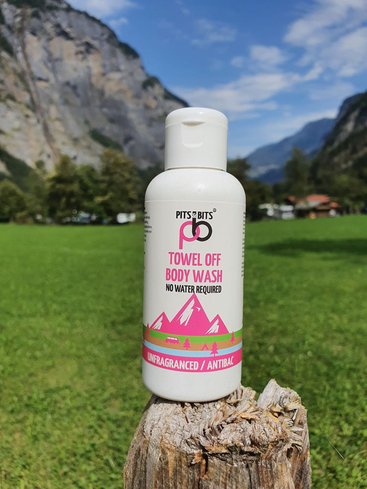 Front view of the Pits & Bits Towel Off Body Wash bottle with pink mountain design and “Unfragranced / Antibac” label