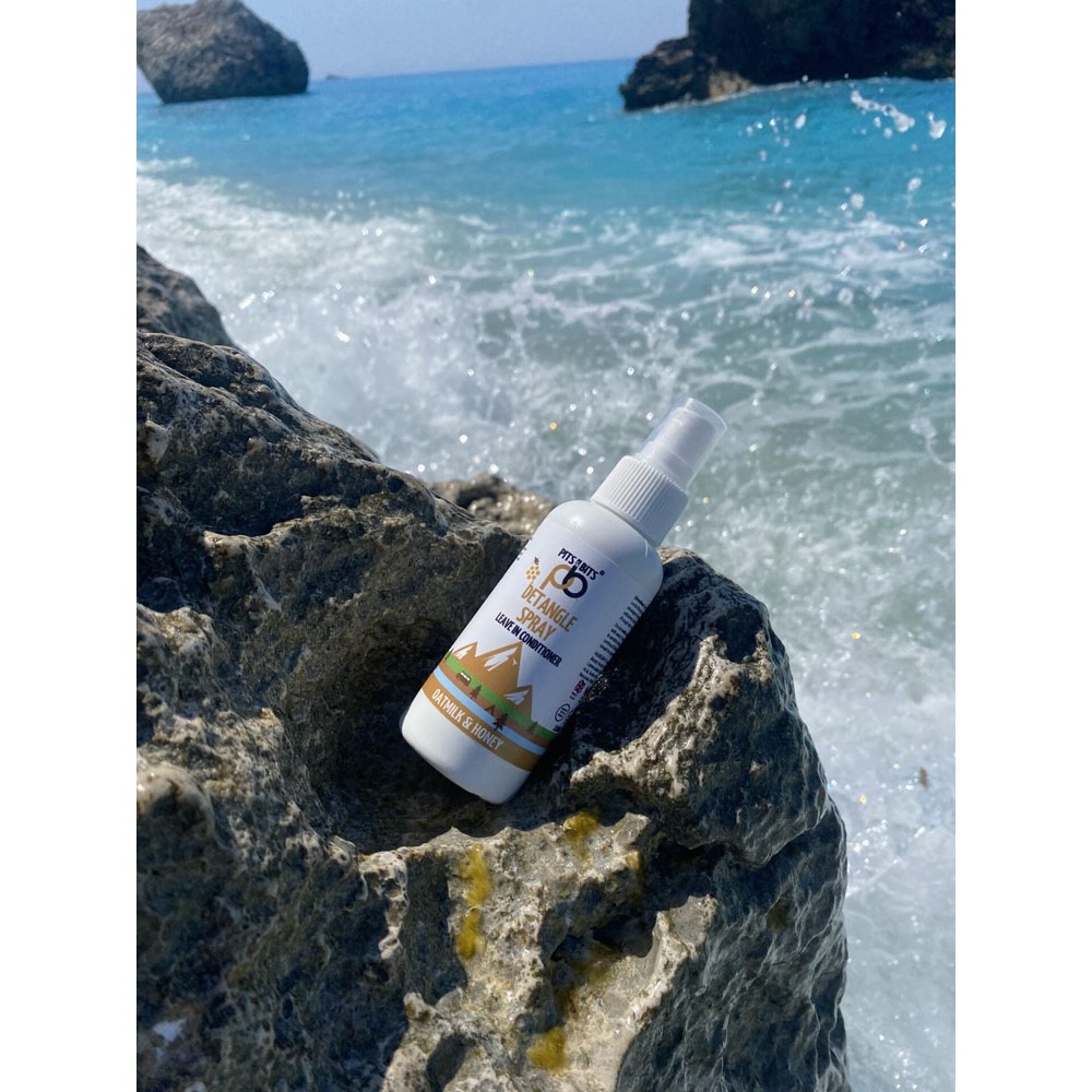 Front view of Pits & Bits Detangle Spray bottle featuring oatmilk and honey label with mountain design on white background.