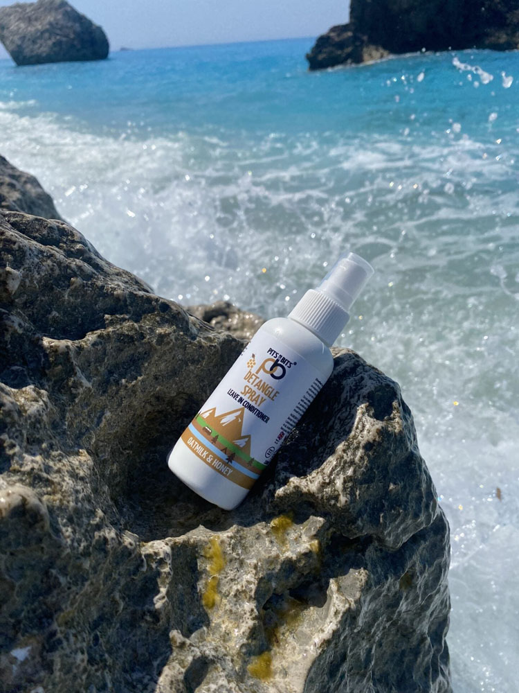 Front view of Pits & Bits Detangle Spray bottle featuring oatmilk and honey label with mountain design on white background.