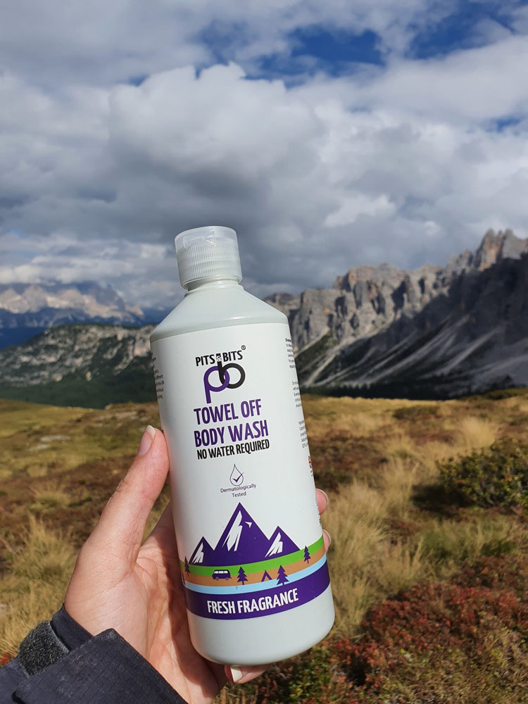 Front view of Pits & Bits Towel Off Body Wash bottle with purple mountain design and “Fresh Fragrance” label on white background.