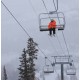 Person Using SOL Blanket XL on Ski Lift in Cold Weather Skier wrapped in SOL Emergency Blanket XL for warmth and visibility on mountain chairlift