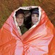 Two People Using SOL Emergency Blanket XL – Heat Retention and Protection Couple wrapped in SOL Emergency Blanket XL with reflective interior and high-visibility orange exterior for emergency shelter and warmth