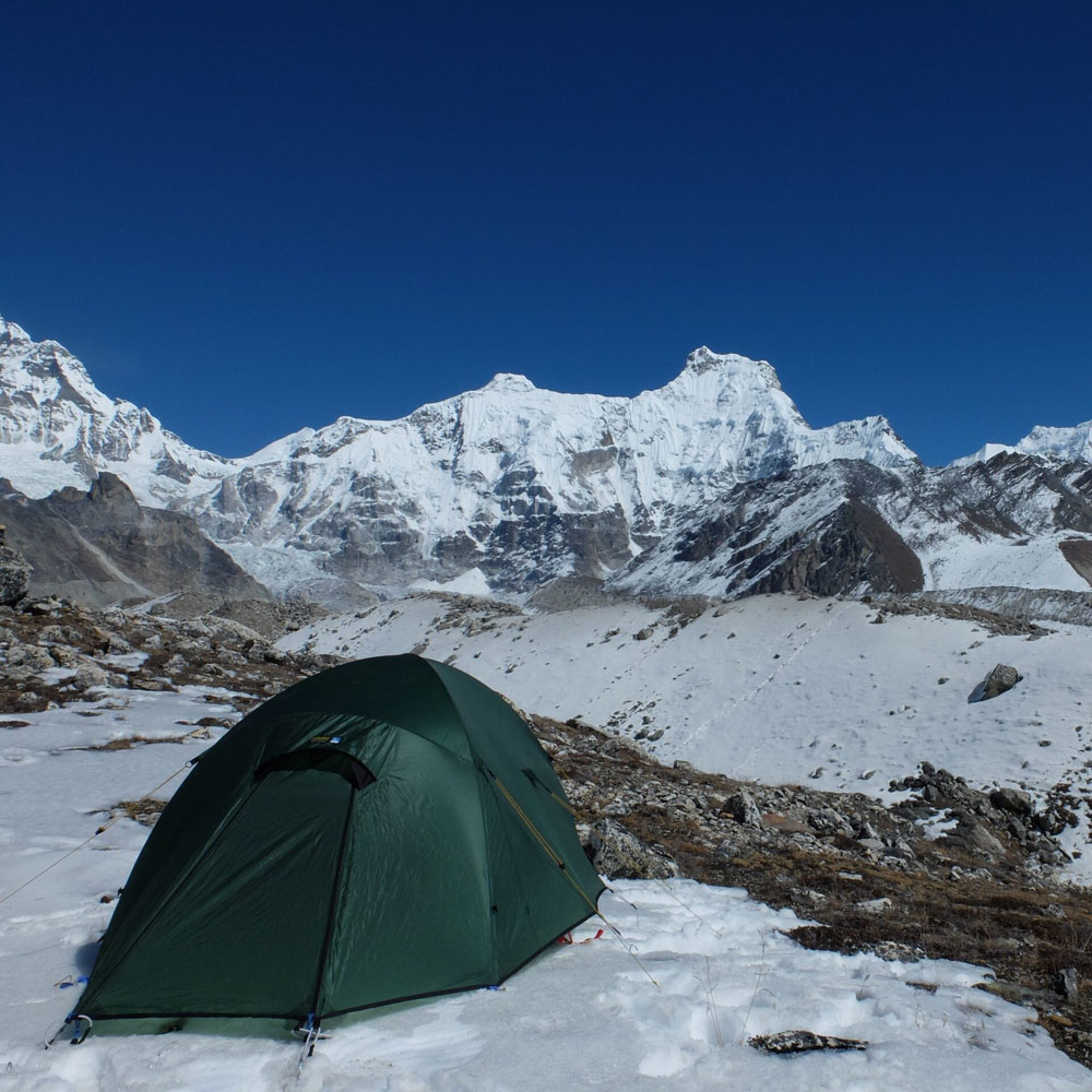 Terra Nova Quasar tent pitched on snowy alpine terrain with snow-covered peaks in the background.