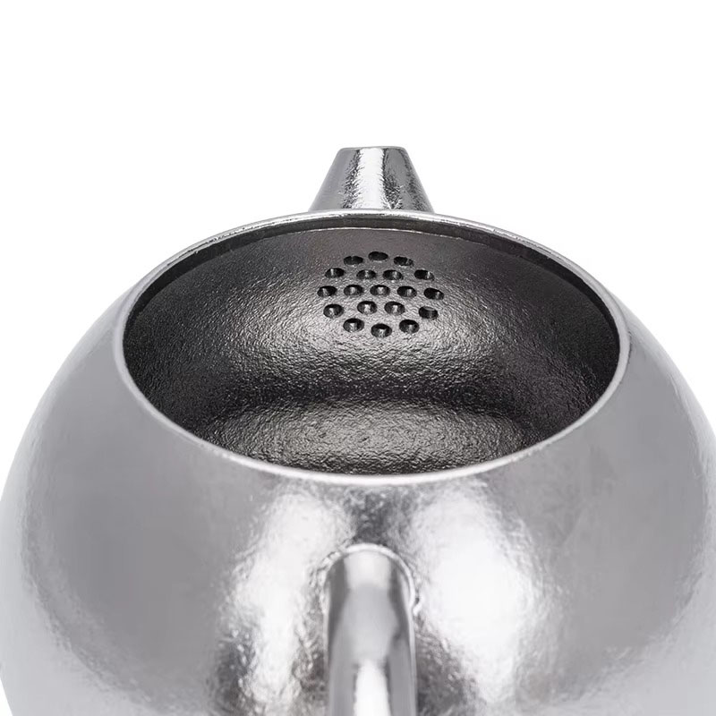 Boundless Voyage 180ml titanium teapot featuring a lightweight hammered-finish titanium body, integrated handle, precision pouring spout, and fitted lid with steam vent. Designed for brewing loose-leaf tea with a built-in strainer at the spout, this compa