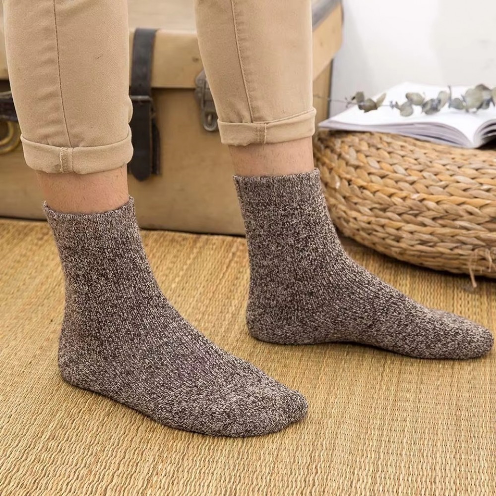 Person wearing thick winter merino wool thermal socks designed for warmth, comfort and insulation during cold weather and indoor lounging