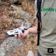 Brunton TruArc™ 20 Compass – In Hand Outdoors Person using Brunton TruArc™ 20 compass in wilderness with lanyard attached, surrounded by nature.