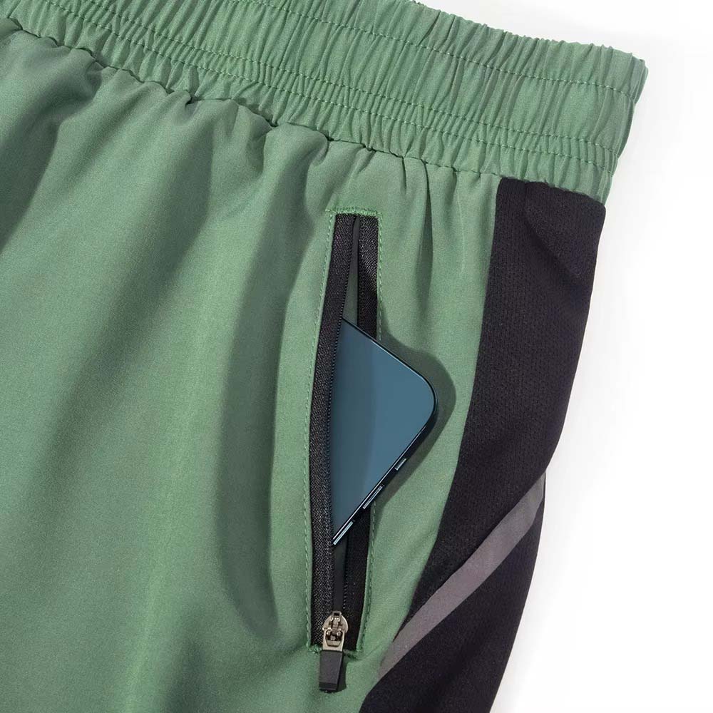 Close-up of ARSUXEO men’s quick dry running shorts in green, showing secure zipper pocket with phone storage.