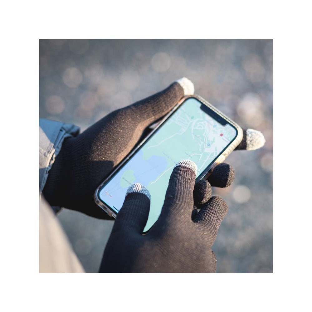 Person using a smartphone outdoors with grey-tipped Extremities gloves, demonstrating touchscreen compatibility.
