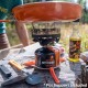 Jetboil MiniMo Stove with Pot Support – Outdoor Cooking Setup Jetboil MiniMo with metal pot support and Jetpower fuel on rocky surface, ideal for rugged terrain cooking