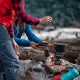 Campers Cooking with Jetboil MiniMo – Wilderness Meal Prep Campers preparing food using Jetboil MiniMo stove on a log, lakeside wilderness setting