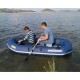 Two people using a blue inflatable boat on calm water for recreational boating fishing and outdoor lake adventures